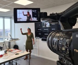 Videocamera capturing a lady talking in a classroom